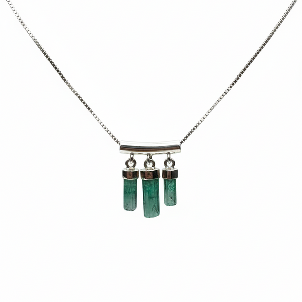 Necklace with green cylindrical pendants on a white background
merald necklace with Colombian emerald